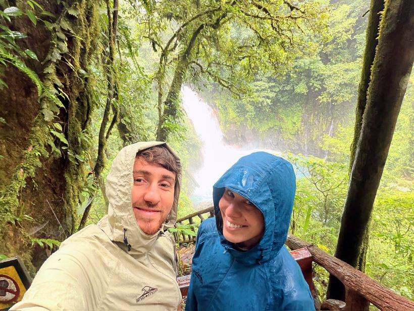 Los dos frente a la catarata, con lluvia