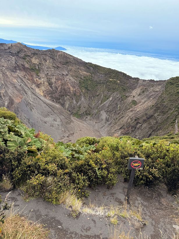 El cráter apareciendo, con el mar de nubes atrás